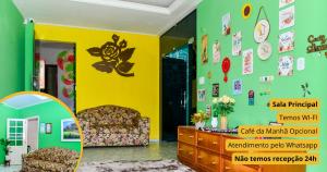 een woonkamer met een stoel en een gele muur bij Casa da Maia Hostel in Tianguá