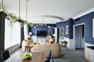 a living room with blue walls and a dining room at Sheraton Heathrow Hotel in Hillingdon