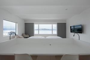 a white room with a large bed and a flat screen tv at Wakkanupuri Resorts in Teshikaga
