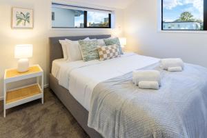 a bedroom with two beds and a nightstand and two windows at Charming Downtown hideaway 1 bed 1 bath in Christchurch