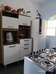 uma cozinha branca com um fogão e um frigorífico branco em Sítio Conquista Feliz em Nova Iguaçu