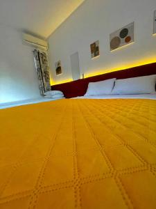 Habitación de hotel con cama con edredón amarillo en Marlindo Hospedagem, en Penha