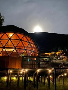 a large building with lights in front of it at Glamping BRILLO DE LUNA in Guatavita