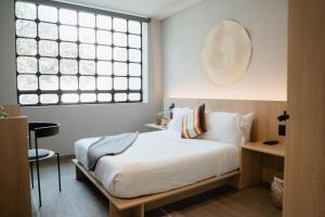 a bedroom with a white bed and a window at Casa Lomah WTC in Mexico City