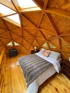 Cama en habitación con techo de madera en Glamping BRILLO DE LUNA, en Guatavita