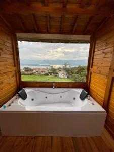 a bath tub in a room with a large window at Glamping BRILLO DE LUNA in Guatavita