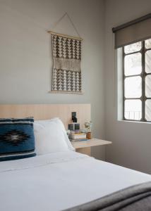 a bedroom with a white bed and a window at Casa Lomah WTC in Mexico City