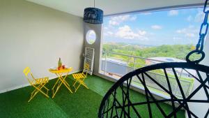 a room with a balcony with a swing at Appartement Océan View in Le Robert