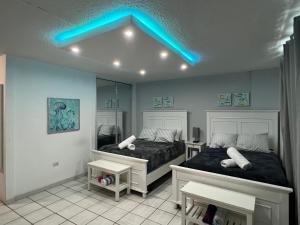 a bedroom with two beds and a blue light at Isla Verde Puerto Rico, Two Full Beds in San Juan