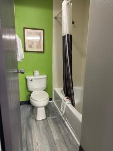 a bathroom with a toilet and a green wall at La Quinta Inn by Wyndham Omaha Southwest in Omaha