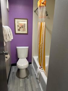 baño con aseo y pared púrpura en La Quinta Inn by Wyndham Omaha Southwest, en Omaha