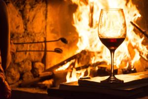 a glass of wine sitting in front of a fireplace at La Posada de Tafi in Tafí del Valle