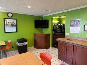 a restaurant with green walls and a tv on the wall at La Quinta Inn by Wyndham Omaha Southwest in Omaha