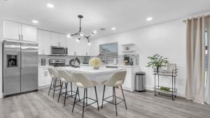 eine weiße Küche mit einem weißen Tisch und Stühlen in der Unterkunft Sunny Escape: 5BD Home in Miami