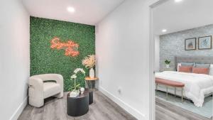 ein Schlafzimmer mit einem Bett und einer grünen Wand in der Unterkunft Sunny Escape: 5BD Home in Miami