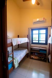 a room with two bunk beds and a window at Pousada Casarão in Imbituba