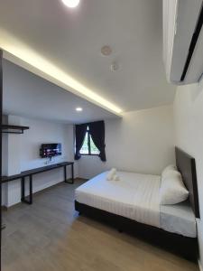 1 dormitorio con 1 cama y TV en E Hotel en Kulim