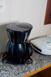 a black coffee pot sitting on top of a counter at Pousada Casarão in Imbituba