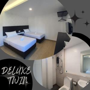 una camera d'albergo con due letti e un bagno di E Hotel a Kulim