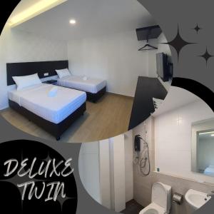 a hotel room with two beds and a bathroom at E Hotel in Kulim