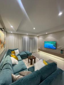 een woonkamer met een blauwe bank en een tv bij Blue Apartment vue sur l’océan : Taghazout bay in Taghazout