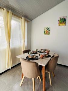 d'une salle à manger avec une table, des chaises et une fenêtre. dans l'établissement Lugar encantador super equipado, à Popayan