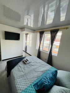 a bedroom with a bed and a flat screen tv at Lugar encantador super equipado in Popayan