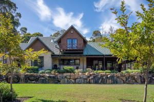 a large house with a stone wall at Tintagel Estate I Private Properties in Forest Grove