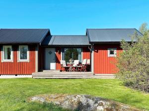 uma casa vermelha e preta com uma mesa e cadeiras em Holiday home GRÄNNA VI em Gränna