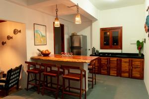 a kitchen with a island with bar stools at Casa Aeolus in Camocim