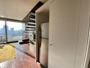 a kitchen with a refrigerator next to a staircase at Loft Panoramico - Santiago in Santiago