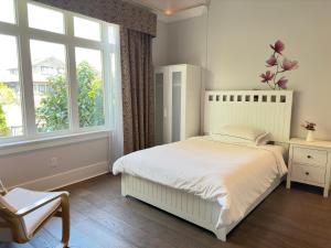 1 dormitorio con cama blanca y ventana en Vancouver West Cozy Retreat by Host Launch en Vancouver