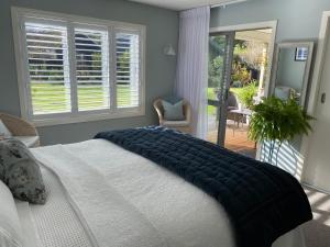 a bedroom with a bed with a blanket on it at Tregandale in Greytown