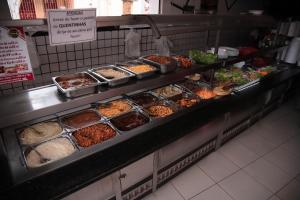 a buffet line with many different types of food at HOTEL, RESTAURANTE E LANCHONETE PRIME in Valença