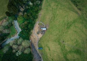 an aerial view of a field with a river and a house at Pāmu PurePod in Rotorua