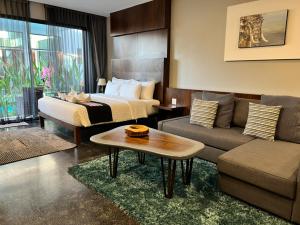 NAI YA Hotel -SHA Extra Plus في شيانج راي: غرفه فندقيه بسرير واريكه