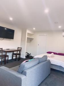 Sala de estar con 2 camas, sofá y mesa en Colac Otway Caravan & Cabin Park en Colac