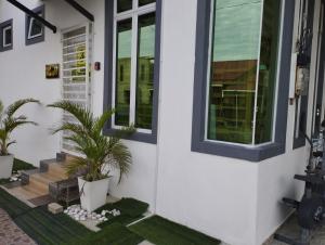 una casa con plantas en el porche delantero en Inap Idaman 3 Near Hospital USM Kubang Kerian en Kota Bharu