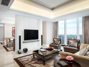 a living room with a couch and a tv at The St. Regis Chengdu in Chengdu