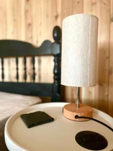 a lamp sitting on a table next to a bed at Le Martin Pecheur 2 chambres in Nouvelle