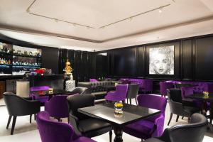 a restaurant with purple chairs and tables and a bar at Four Points by Sheraton Bandung in Bandung