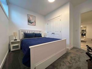 1 dormitorio con 1 cama con edredón azul en Cozy Retreat - Basement Hideaway - Closest to Banff in Calgary, en Calgary