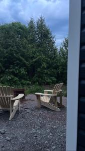 two chairs and a bench sitting in a park at Chalet La Renarde in Nouvelle