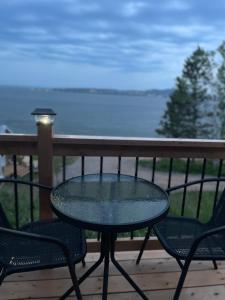 a table and chairs on a balcony with a view of the ocean at Chalet La Renarde in Nouvelle