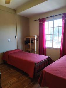 a bedroom with two beds and a window at Departamento Aires del Golf in Termas de Río Hondo