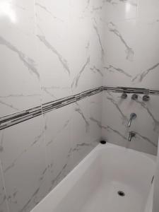 a bathroom with a bath tub with marble tiles at Departamento Aires del Golf in Termas de Río Hondo