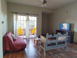 a living room with a couch and a flat screen tv at Departamento Aires del Golf in Termas de Río Hondo