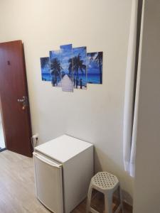 a room with a white refrigerator and a stool at Hospedaje MorroSP in Morro de São Paulo
