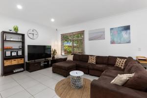 een woonkamer met een bank en een flatscreen-tv bij Endless Summer House - Aldinga Beach - C21 SouthCoast Holidays in Aldinga Beach