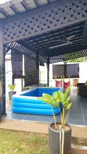 a blue pool in the middle of a patio at Rosspine Homestay in Jitra